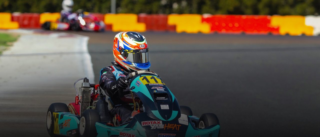 A kart on the racing line, kerbs blurred by speed